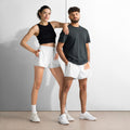 Two people wearing matching athletic outfits with white shorts and black tops against a plain background.