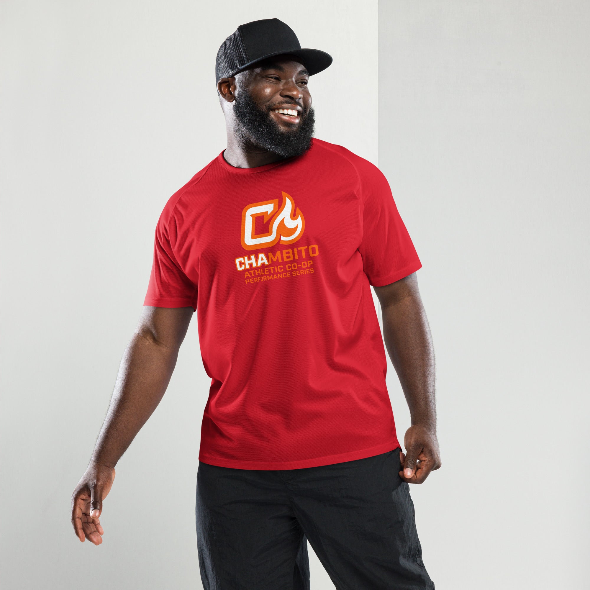 Man wearing a red t-shirt with a logo and text, standing against a plain background